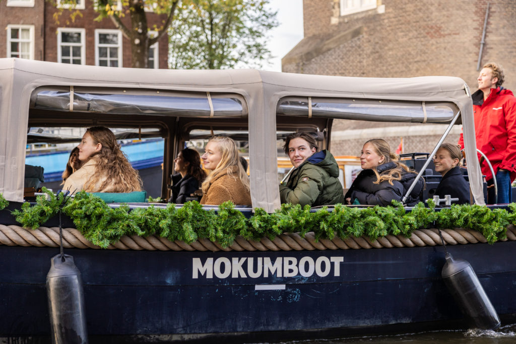 Überdachtes Kanalboot mit Weihnachtsschmuck.