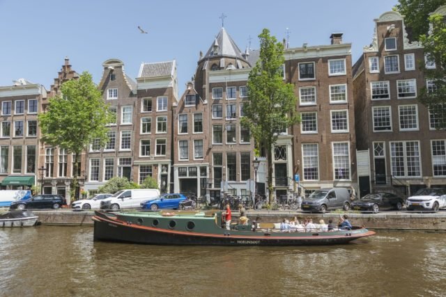 Schleppboot f&auml;hrt an der Magere Brug in Amsterdam vorbei